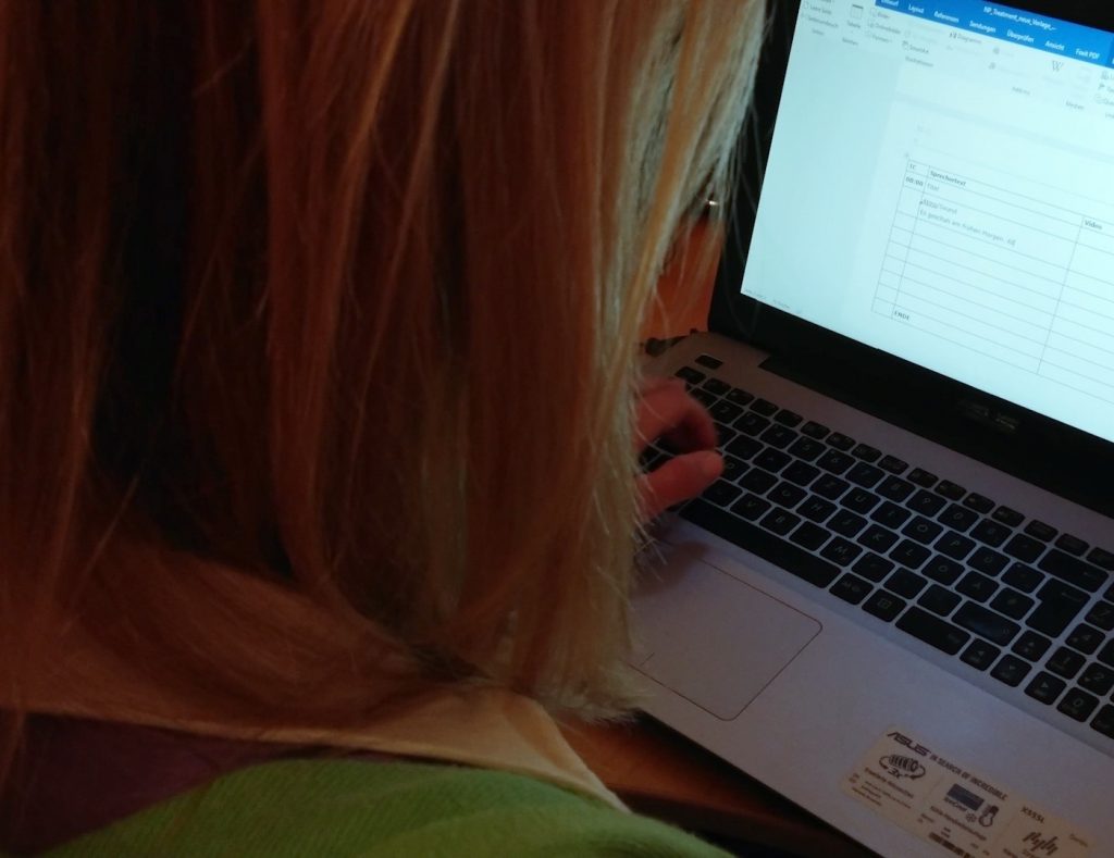 Sonja Schwaighofer von Crossmedia Schwaighofer vor Laptop beim schreiben eines Treatments